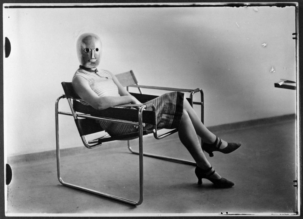 Femme portant un masque d’Oskar Schlemmer dans un fauteuil tubulaire de Marcel Breuer, vers 1926