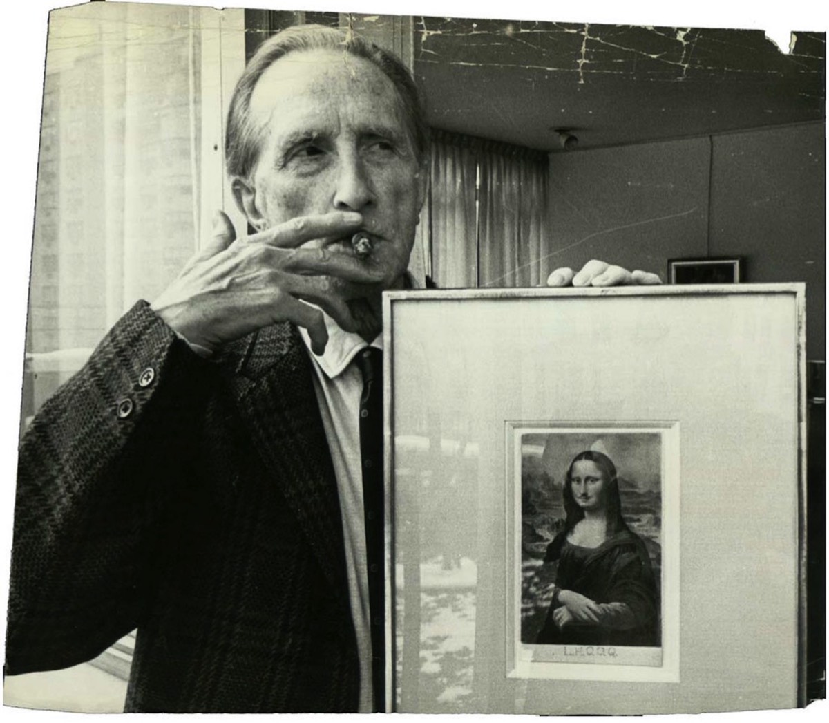 Marcel Duchamp avec un cadre de  L.H.O.O.Q